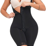 Mulher em macacão preto usando uma cinta cirúrgica de cintura alta, destacando sua silhueta elegante e moderna.